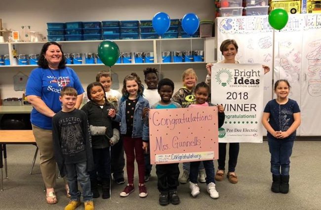 Teachers and students posing with check and balloons