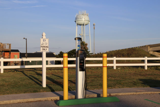 Electric Vehicle charging station in front of water tower that reads "Welcome to Holden Beach"